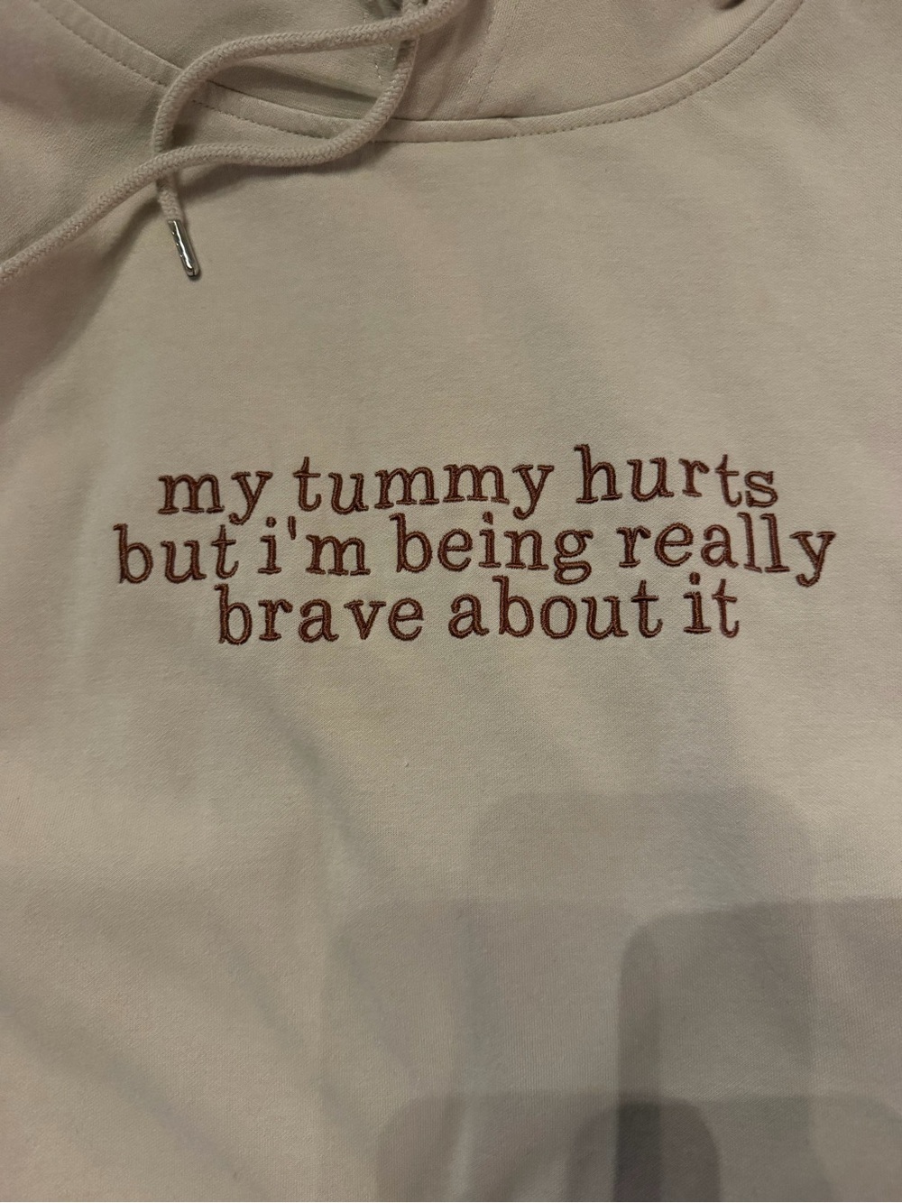 Women’s Khaki Hoodie with Embroidered Brown Text - “my tummy hurts but I’m…”